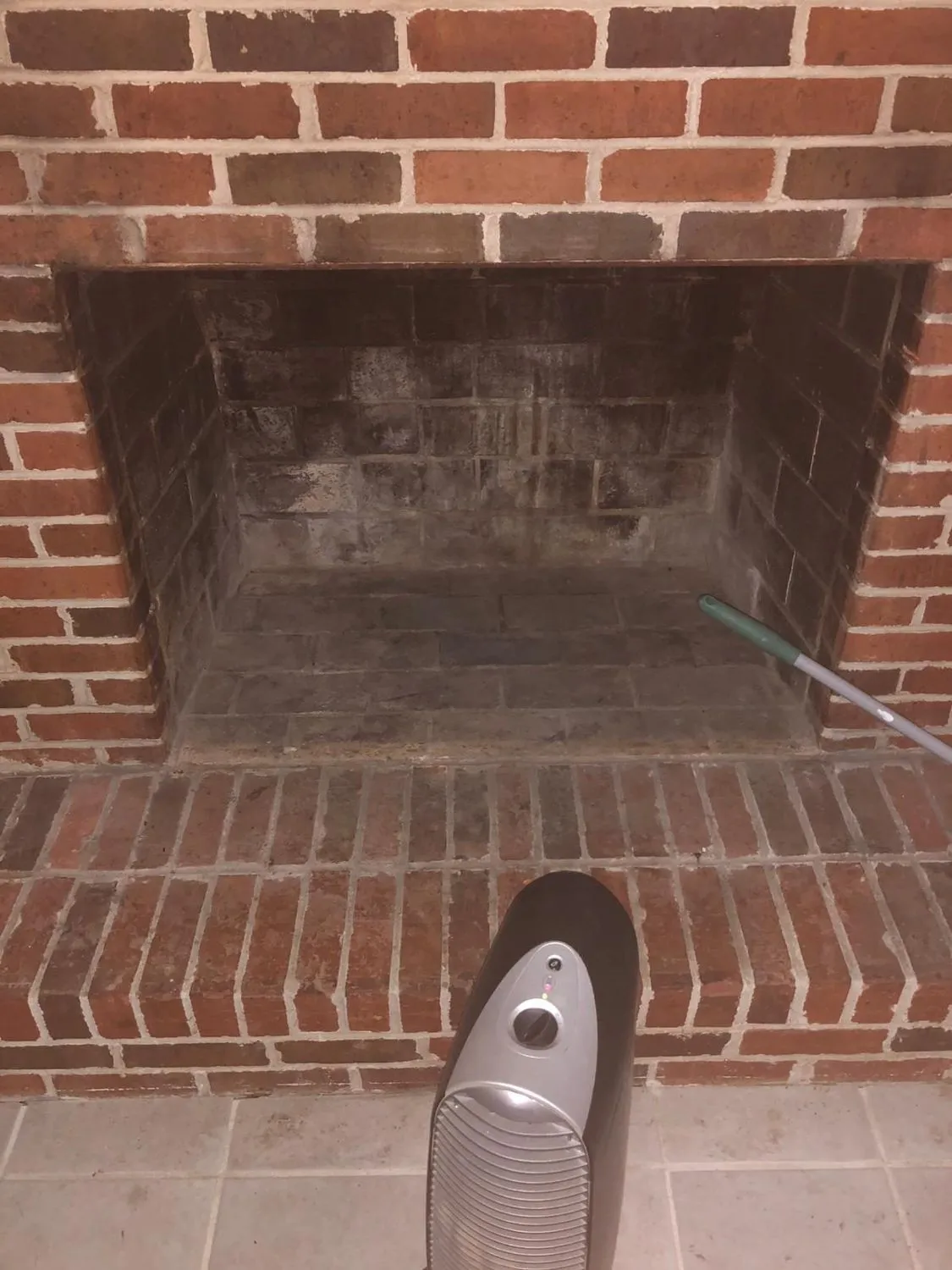 Brick arched firebox being vacuumed during a chimney cleaning