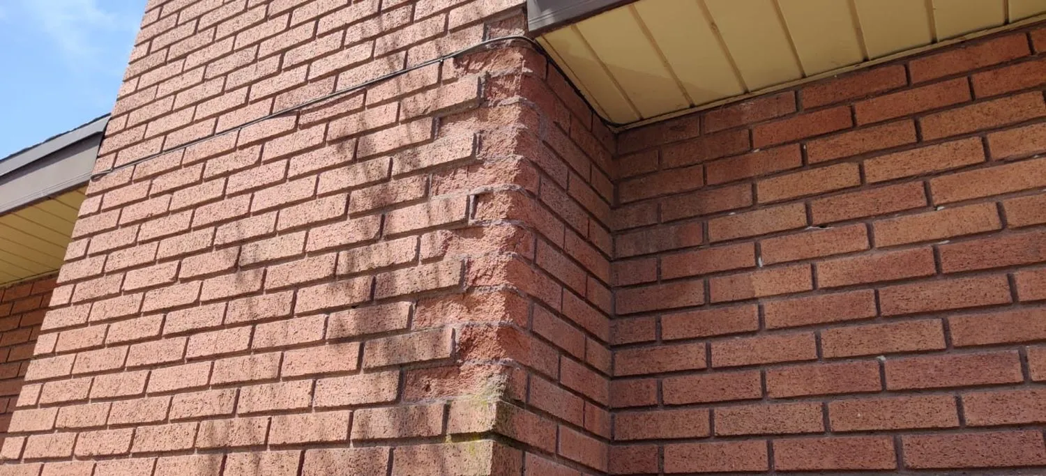 Red brick chimney with fresh tuckpointing at roofline