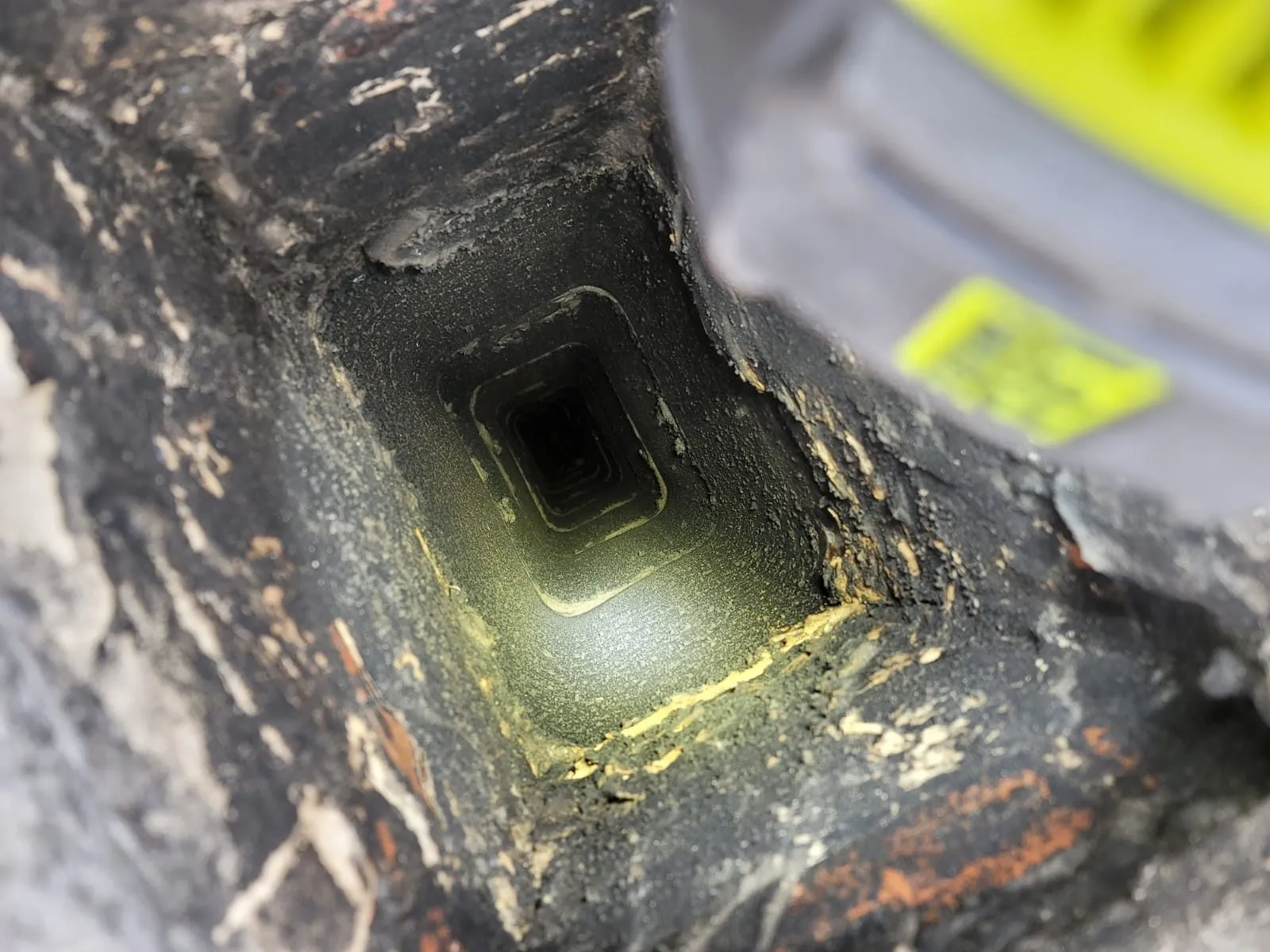 Flashlight beam illuminating dark sooty chimney flue interior