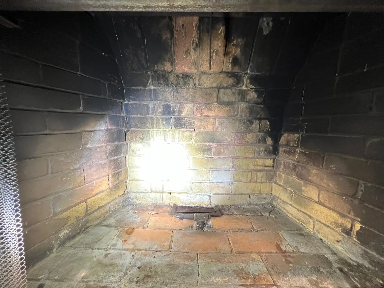 Flashlight inspection of sooty brick firebox walls