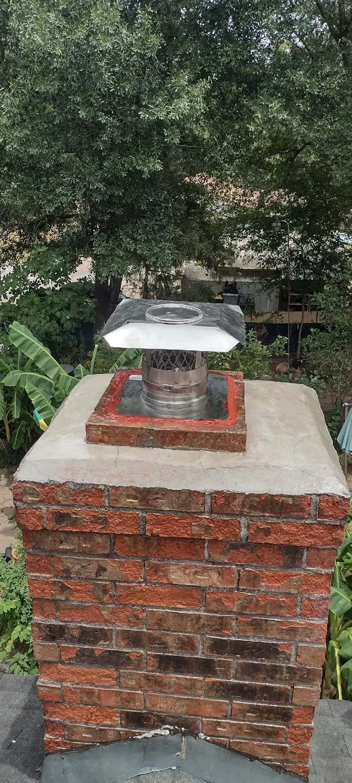 Red brick chimney with new stainless steel cap
