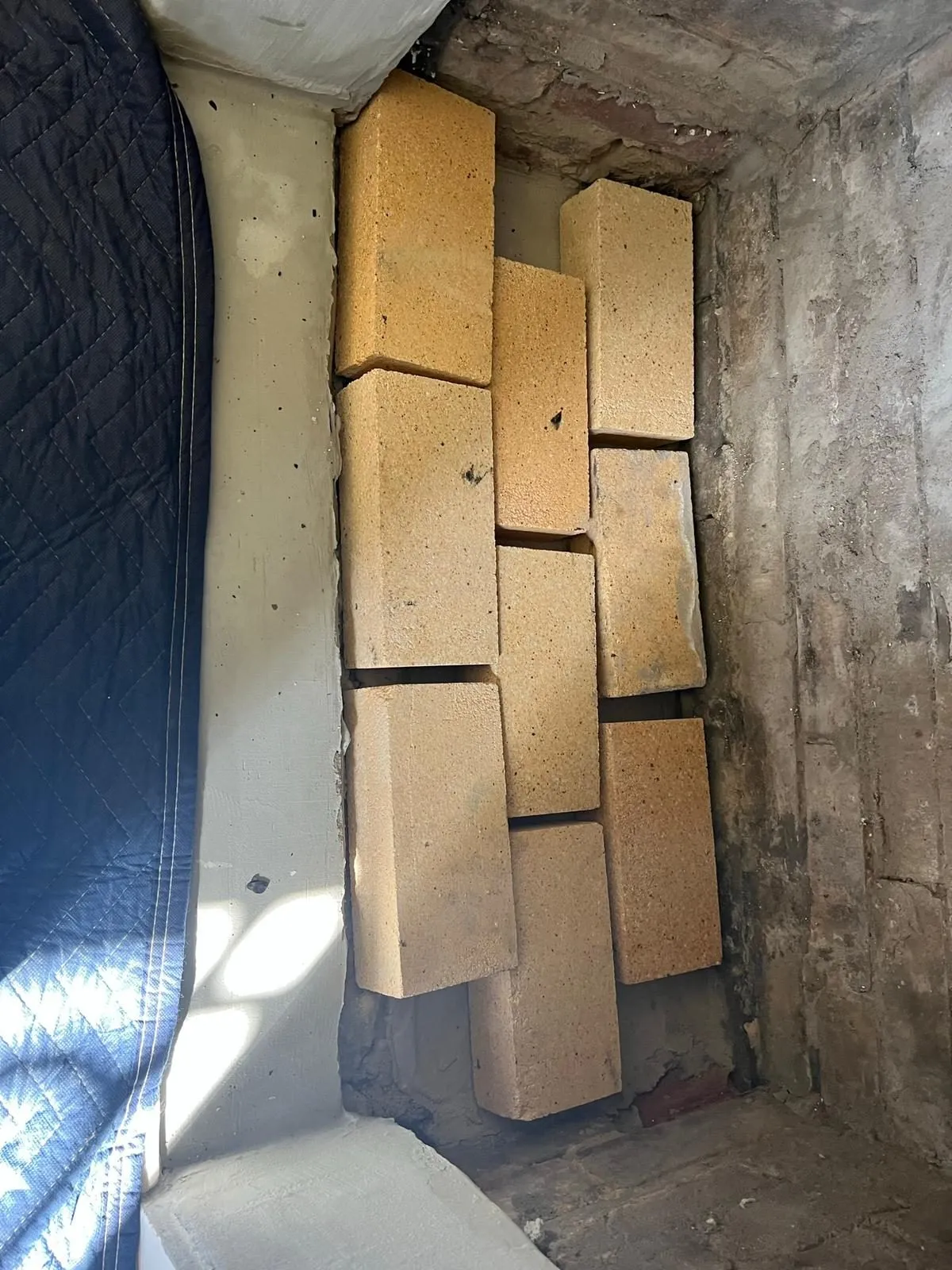 Firebricks stacked inside damaged smoke chamber for rebuild